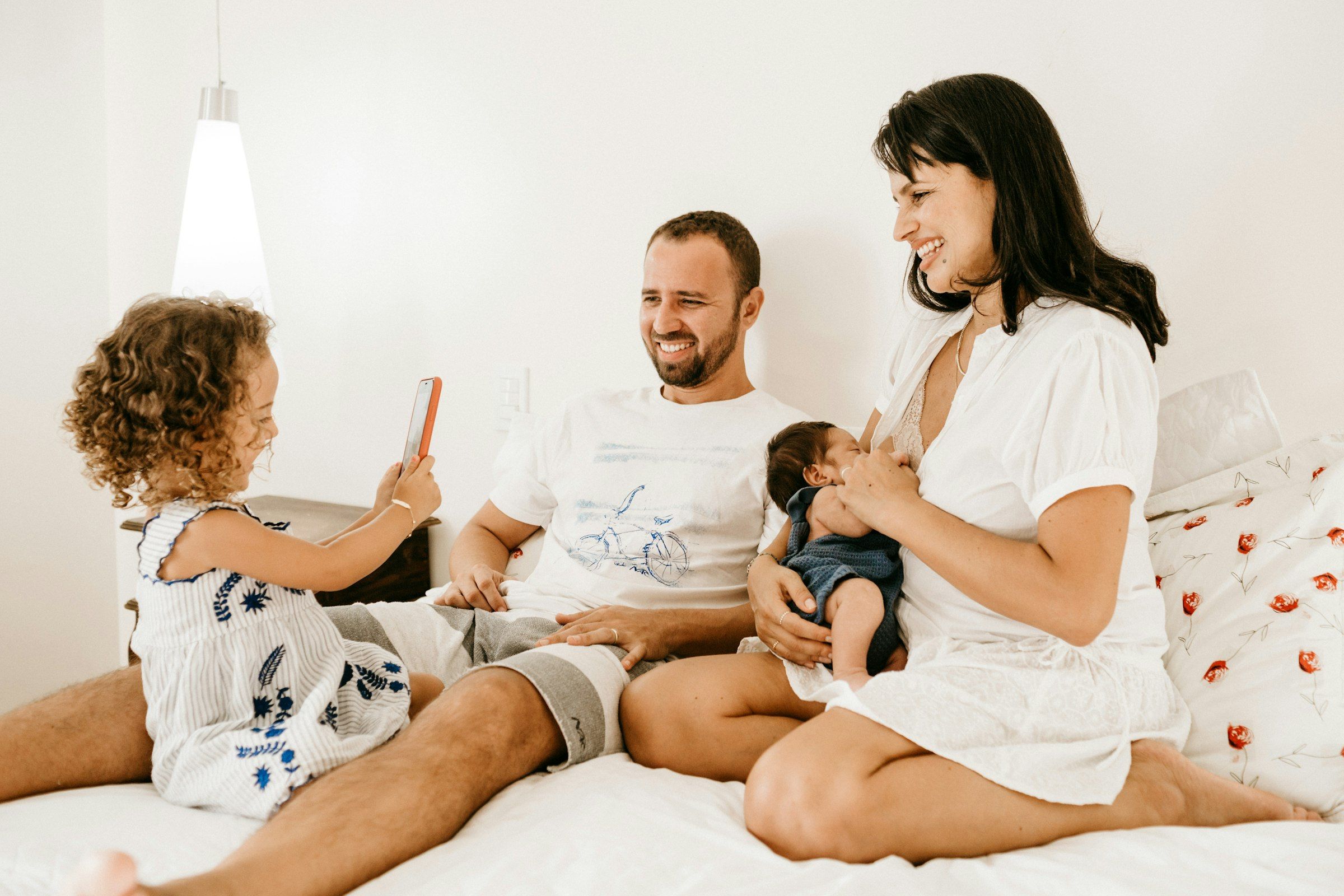 Gülümseyen anne, baba ve kız çocuğundan oluşan mutlu bir aile